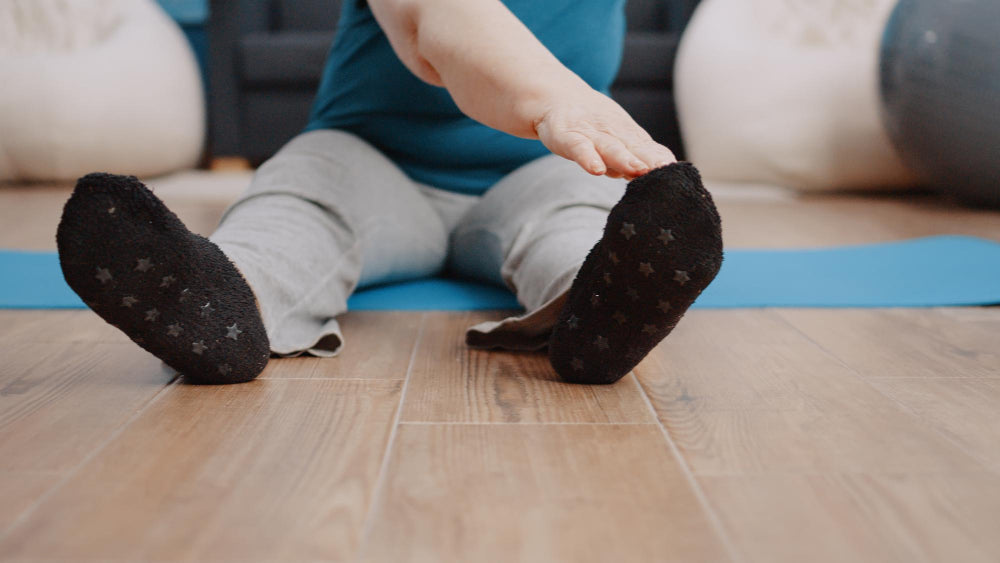 Close-up of old person doing warm up exercises and using grip socks