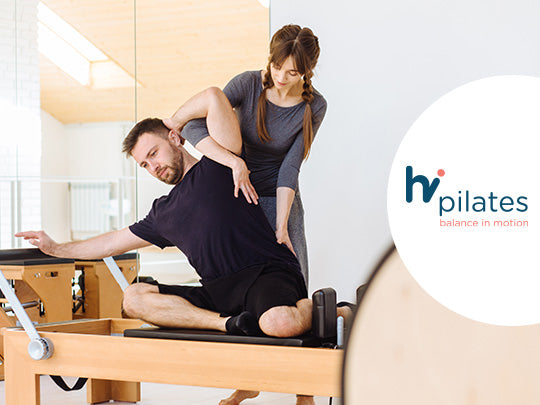 Pilates coach trains her student while on a reformer