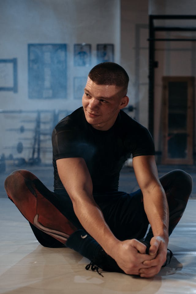 a man in black doing some warmups before doing pilates